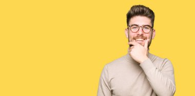 Genç yakışıklı iş adamı olduğuna emin çapraz kollar ve çeneme kaldırdı el ile gülümseme ile kameraya bakıyor. Pozitif düşünce.