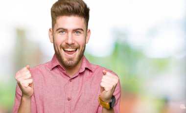 Casual adam kutluyor şaşırttı ve silah ile başarı için hayran genç yakışıklı iş kaldırdı ve gözleri açık. Kazanan kavramı.