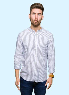 Genç yakışıklı adam dudaklarıyla balık suratı yapıyor, çılgınca ve komik bir jest. Komik ifade.