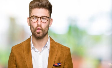 Genç yakışıklı iş adamı giyen dudaklı, çılgın ve komik bir jest yapma balık yüz gözlük. Komik ifade.