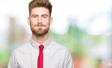 Genç yakışıklı iş adamı komik surat ile yanakları şişirme. Ağız ile hava, deli ifade şişirilmiş.