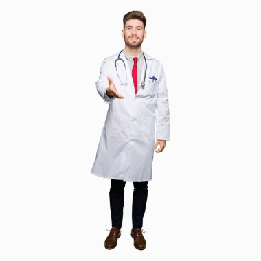 Tıbbi giyen genç yakışıklı Doktor adam kat tebrik ve davet edici olarak gülümseyen dostu sunan el sıkışma. Başarılı iş.