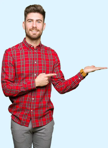 Joven Hombre Guapo Sorprendido Sonriendo Cámara Mientras Presenta Con Mano — Foto de Stock