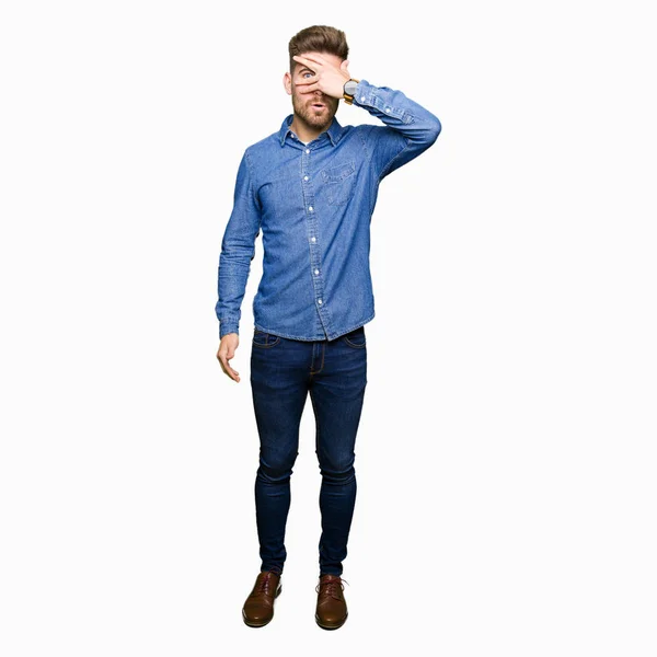 Young Handsome Blond Man Wearing Casual Denim Shirt Peeking Shock — Stock Photo, Image