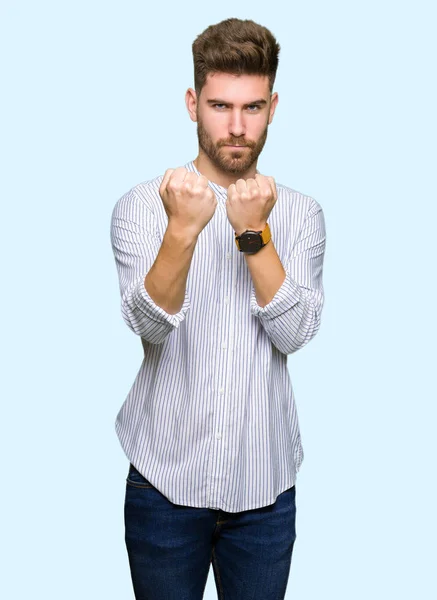 Young handsome man Ready to fight with fist defense gesture, angry and upset face, afraid of problem