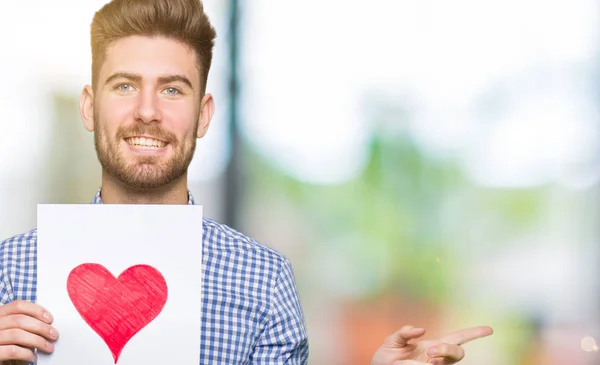 Young Handsome Man Holding Paper Red Heart Very Happy Pointing — Stock Photo, Image