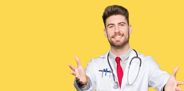 若いハンサムな医者はハグするため両手を広げて笑みを浮かべてカメラを見て医療のコートを着ている男 晴れやかな表情の受け入れ幸せ — ストック写真