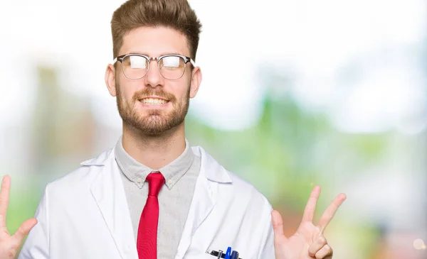 年轻英俊的科学家戴着眼镜 用手指指着八号 面带微笑 自信而快乐 — 图库照片