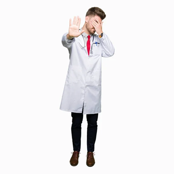Mladý Pohledný Doktor Muž Nosí Lékařský Plášť Pokrývající Oči Rukama — Stock fotografie