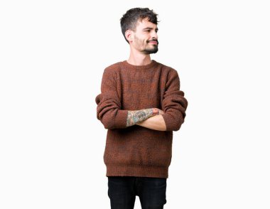 İkna ve kendine güvenen tarafına silahlarla seyir gülümseyen izole arka plan üzerinde kış kazak giyen genç yakışıklı adam geçti