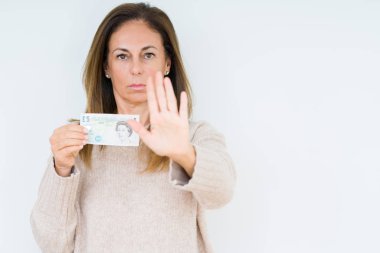 5 pound banknot açık eliyle dur işareti ile ciddi ve kendine güvenen ifade, savunma jest yapıyor izole arka plan üzerinde tutan orta yaş kadın