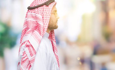 Genç yakışıklı adam giyen keffiyeh izole arka tarafına, seyir üzerinde dinlenmek doğal yüz emin gülümseme ile pozuyla profili.