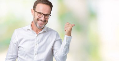 Seyir ve başparmak yanında yukarıyı mutlu yüz ile gülümseyen izole arka plan üzerinde gözlük takan yakışıklı orta yaş zarif üst düzey iş adamı.