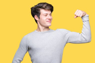 Kış kazak kol kas, kendinden emin ve güç gurur gösteren izole arka plan güçlü kişi üzerinde giyen genç yakışıklı adam