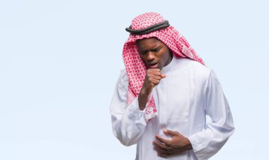 Geleneksel keffiyeh duygu hasta ve soğuk veya bronşit için semptom olarak öksürük izole arka plan üzerinde giyen genç Arapça Afrika adam. Sağlık kavramı.