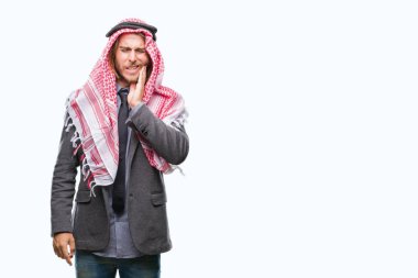 Genç yakışıklı Arap adam uzun saçlı diş ağrısı veya dişlerde dişlerle ilgili hastalık nedeniyle ağız acı ifadesi ile el ile dokunmak izole arka plan üzerinde keffiyeh giyiyor. Diş hekimi kavramı.