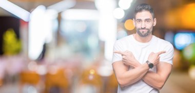 Gece boyunca açık havada beyaz t-shirt giyen yakışıklı adam arka plan işaret parmakları ile her iki taraf için farklı yönde katılmıyorum