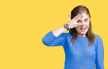 Mahcup ifadeyle parmaklarımın arasından seyir yüz ve gözler el ile kapsayan şok izole arka plan bakmak üzerinde kış kazak giyen güzel orta yaş Olgun kadın.