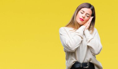 Genç güzel kadın rahat beyaz kazak uyku yorgun hayal ve ile gülümseyen gözleri kapalı iken ellerle birlikte poz izole arka plan üzerinde.