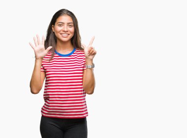 Genç güzel Arap kadın gösterilen ve parmakları ile işaret izole arka plan yüzünden kendinden emin ve mutlu gülümseyerek süre yedi numara.