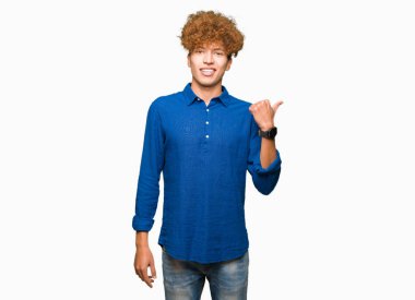 Seyir ve başparmak yanında yukarıyı mutlu yüz ile gülümseyen afro saçlı Genç yakışıklı zarif adam.