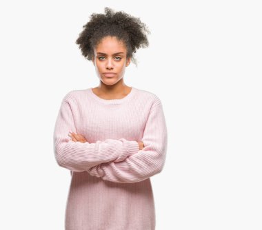 İzole arka plan şüpheci ve sinir, onaylamayan ifade yüz çapraz kolları üzerinde kış kazak giyen genç afro Amerikalı kadın. Negatif kişi.