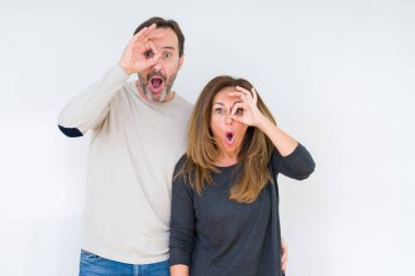 Sürpriz yüz, göz parmaklarının arasından seyir ile güzel orta yaş kaç aşk ok jest yapıyor izole arka plan üzerinde sonra şok. İmansız ifade.