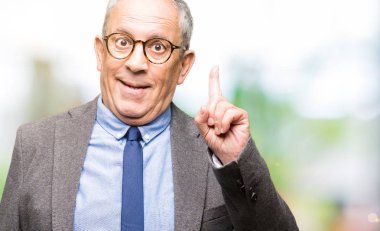 Yakışıklı üst düzey businesss gözlük adam ve işaret parmağı ile başarılı fikir bağla. Çıktıktan ve mutlu. Bir numara.