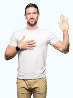 Bir sadakat sözü yemin yapma rahat beyaz t-shirt Swearing göğüs ve avuç, el ile giyen yakışıklı adam