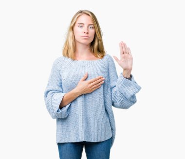 Üzerinde mavi kazak giyen güzel genç kadın izole arka plan göğüs ve bir sadakat sözü yemin yapma avuç, el ile küfür