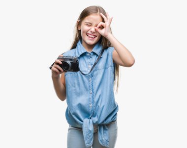 Genç güzel kız mutlu yüz el parmaklarının arasından seyir göz üzerinde ok işaretiyle yapıyor gülümseyen izole arka plan üzerinde Vintage kamera ile fotoğraf çekmek