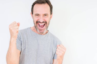 Gülümseyen ve başarı için çığlık yakışıklı üst düzey adam izole arka plan çok mutlu ve heyecanlı kaldırdı, silah ile kazanan jest yapıyor. Kutlama kavramı.