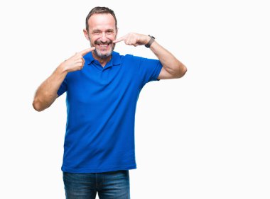 Orta yaş emin gösterilen ve işaret parmakları diş ve ağız ile gülümseyen izole arka plan üzerinde ağarmış komuta sizde. Sağlık kavramı.