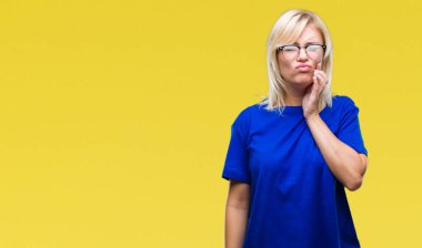 Diş ağrısı veya dişlerde dişlerle ilgili hastalık nedeniyle ağız acı ifadesi ile el ile dokunmak izole arka plan üzerinde gözlük takan genç güzel sarışın kadın. Diş hekimi kavramı.