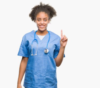 Genç afro Amerikalı doktor kadın ve parmak gülümseyen süre bir numara ile kendinden emin ve mutlu yukarıyı gösteren izole arka plan.