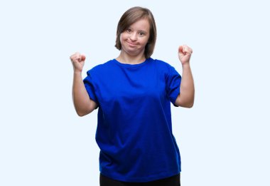 Gülümseyen ve başarı için çığlık Genç Yetişkin kadın izole arka plan çok mutlu ve heyecanlı kaldırdı, silah ile kazanan jest yapıyor üzerinde down sendromlu. Kutlama kavramı.