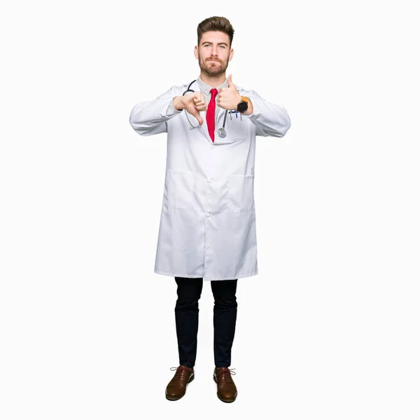 Young Handsome Doctor Man Wearing Medical Coat Doing Thumbs Disagreement — Stock Photo, Image