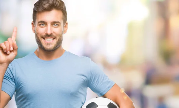 Joven Hombre Guapo Sosteniendo Pelota Fútbol Sobre Fondo Aislado Sorprendido —  Fotos de Stock