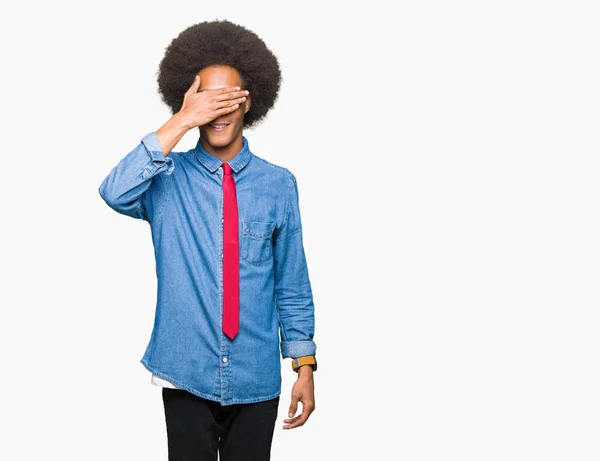 アフロ髪メガネと微笑し 笑う顔を驚きの目を覆って上の手で赤いネクタイを身に着けている若いアフリカ系アメリカ人ビジネスマン視覚障害者の概念 — ストック写真