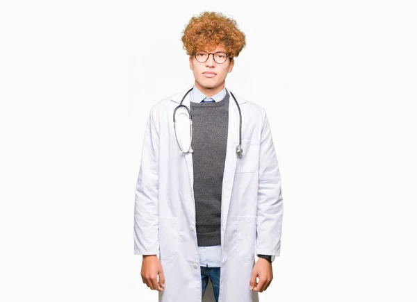 若いハンサムな医者の顔に真剣な表情では男性医療コートを着てリラックス シンプルで自然なカメラを見てください — ストック写真