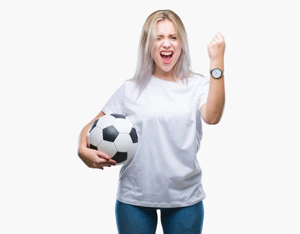 年轻的金发女子拿着足球在孤立的背景恼火和沮丧的喊声与愤怒 疯狂和大喊大叫 举起的手 愤怒的概念 — 图库照片