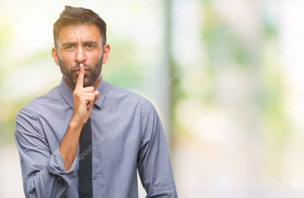 Adult hispanic business man over isolated background asking to be quiet with finger on lips. Silence and secret concept.