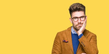 Seyir yorgun ve çapraz kolları olan depresyon sorunları ile sıkılmış düşünme gözlüklü genç yakışıklı iş adamı.