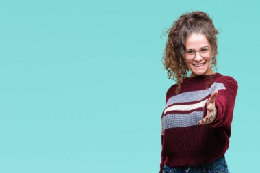 Güzel esmer kıvırcık saçlı Genç kız üzerinde gözlük takan arka plan dostu sunan karşılıklı tebrik ve davet edici gülümseyen izole. Başarılı iş.