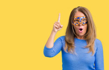 Başarılı fikirle izole arka plan işaret parmağı Venedik karnaval maskesi giyen güzel orta yaş kadın. Çıktıktan ve mutlu. Bir numara.