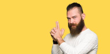 El hareketi ile sembolik silah tutan, çekim silah, kızgın yüz öldürmek oynamaya kış kazak giyen genç hipster adam