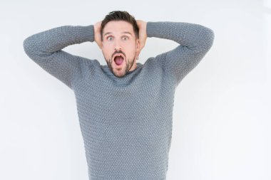 Genç yakışıklı adam giyen sıradan kazak üzerinde arka plan deli izole ve baş, korkuyor ve açık ağzı ile şok sürpriz elleriyle korkuttu