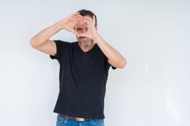 İzole arka plan yaparken kalp şekli ile el ve parmak işareti seyir gülümseyen kıdemli adam