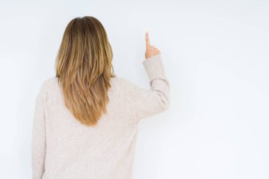 Güzel orta yaş kadın izole arka plan geriye doğru arkasında parmak eliyle işaret Posing