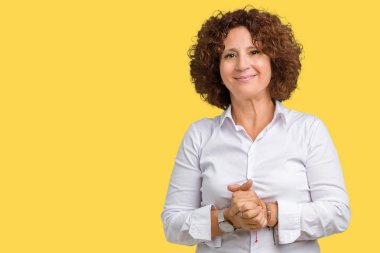 Güzel orta ager üst düzey businees kadın izole arka plan el ele tutusun ve rahat ve neşeli gülümseyen parmak çarpı işareti. Başarı ve iyimser